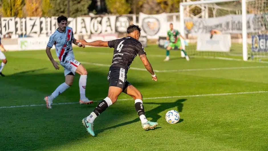 Football players in intense action on a sunny day match in an outdoor stadium.